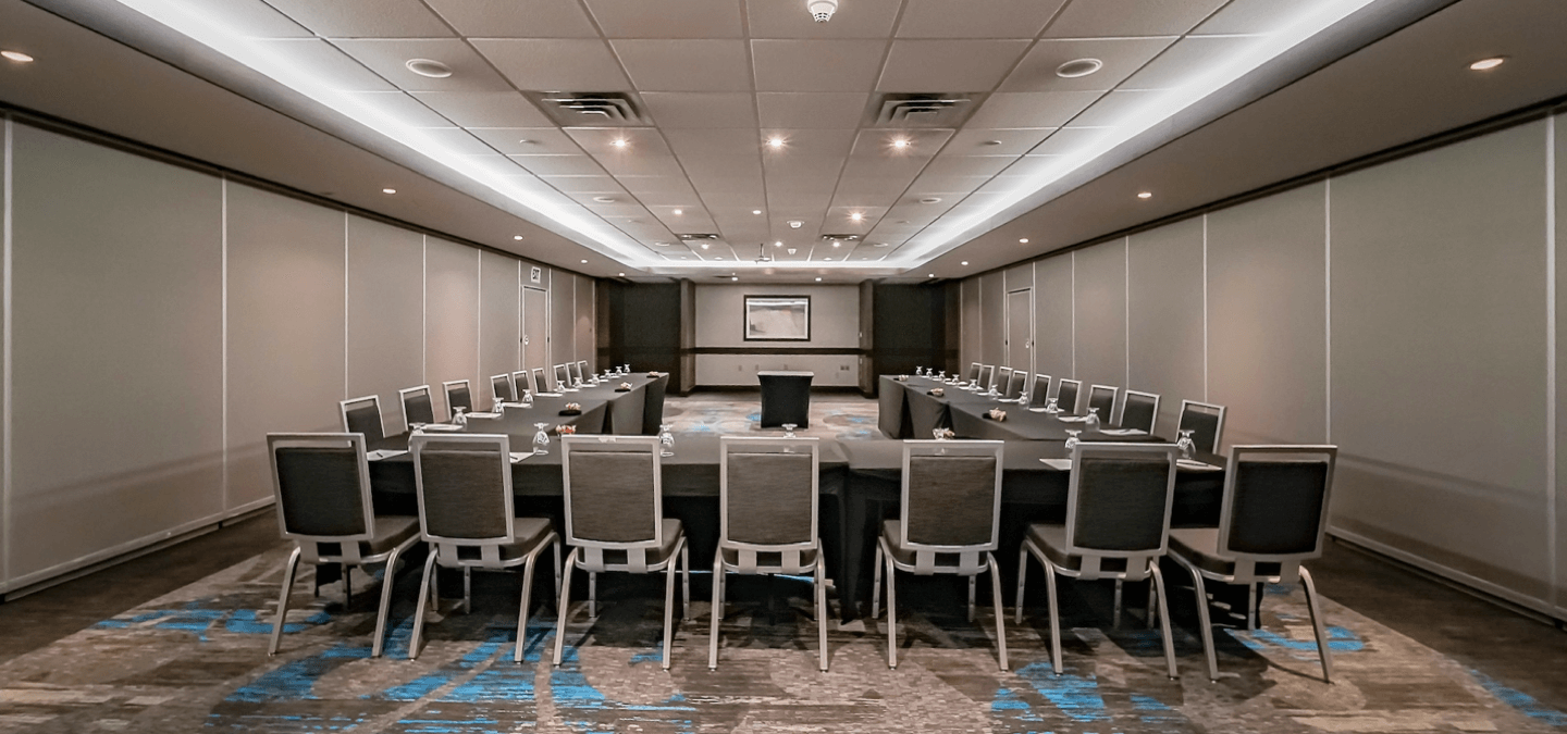 Large, bright meeting room with ample seating and large able in u-shape.